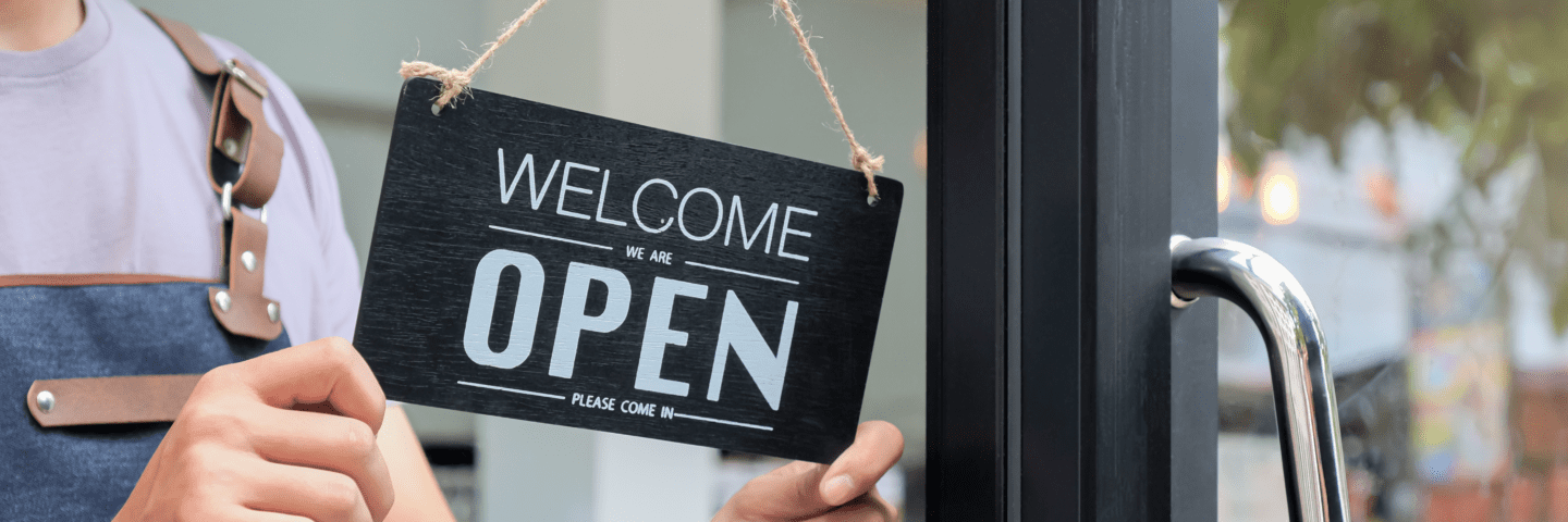 cropped-shot-of-business-owners-hold-an-open-sign-RV6URXV Woman business owner turning 'Business Open' sign on door