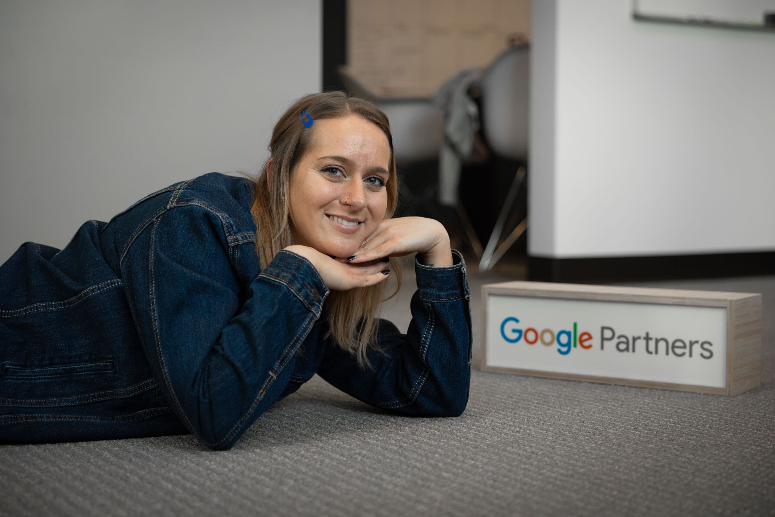 Digital Marketing Specialist, Sara, with Google Partners sign